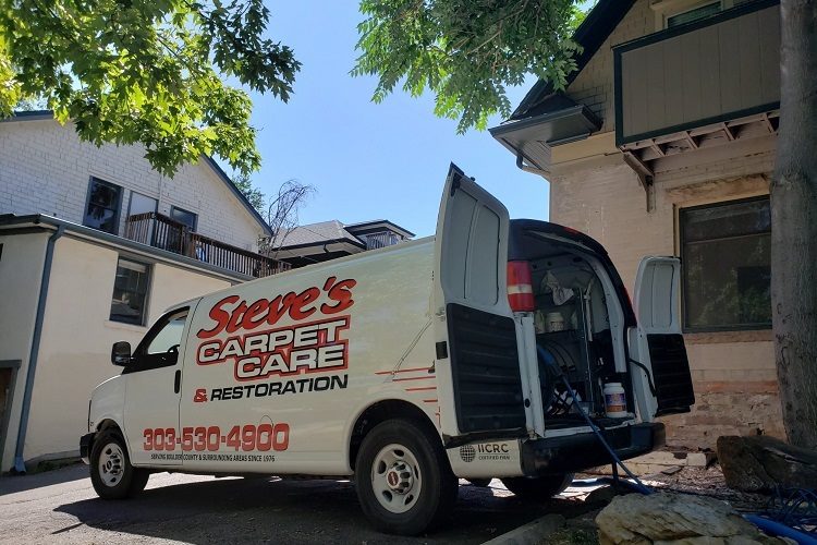 Truck-mounted steam cleaning truck with back doors open outside Boulder, CO home