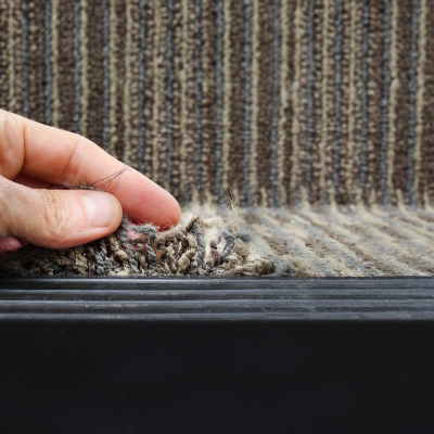 Close-up of frayed and worn carpet fibers