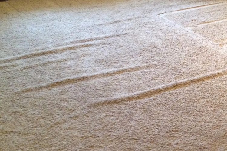 Wrinkled white carpeting in residential living room
