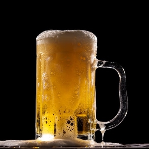 Beer stein overflowing onto table