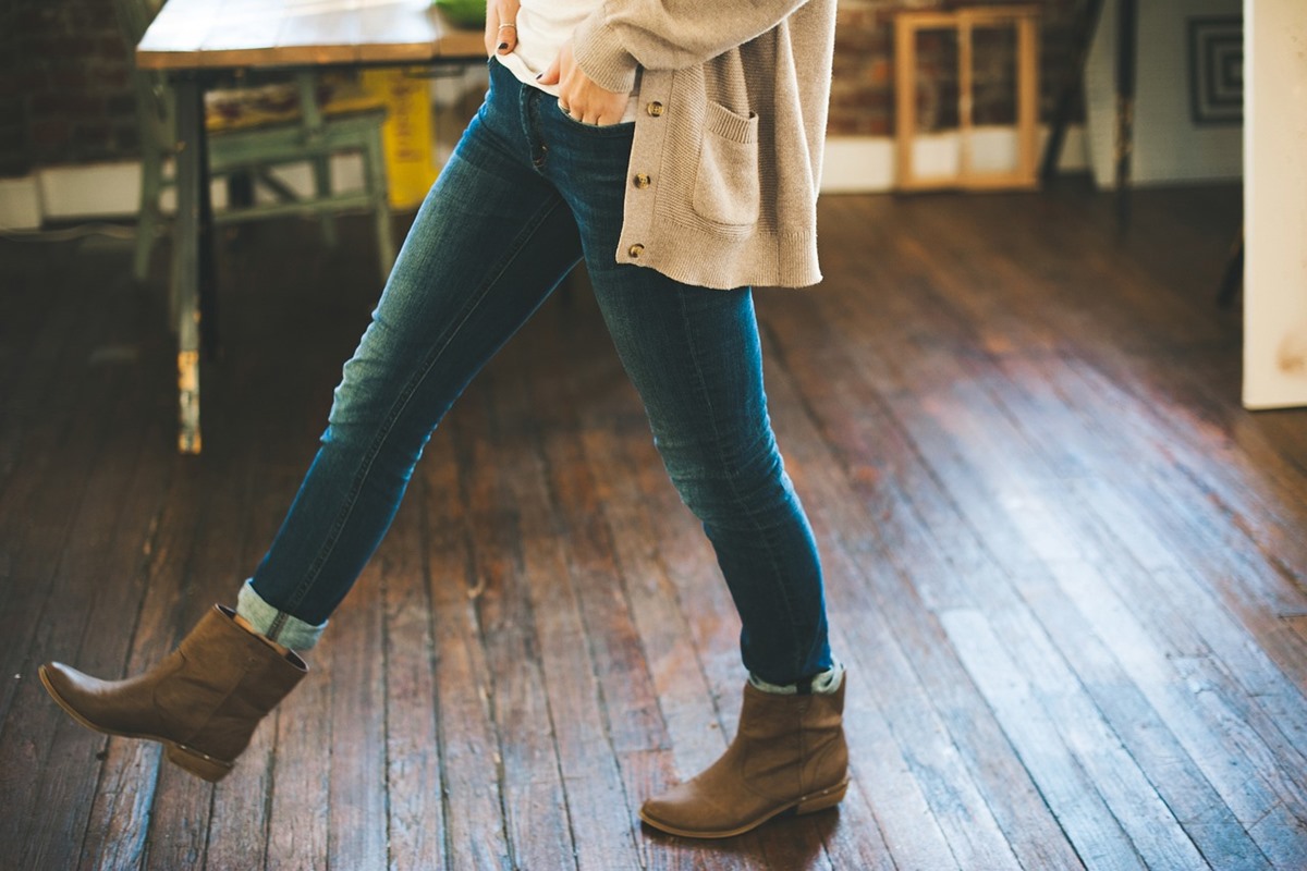 Woman in brown boots on scratched hardwood kitchen floor