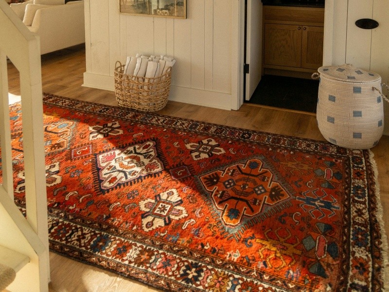 Oriental rug on wooden floor at the bottom of stairway