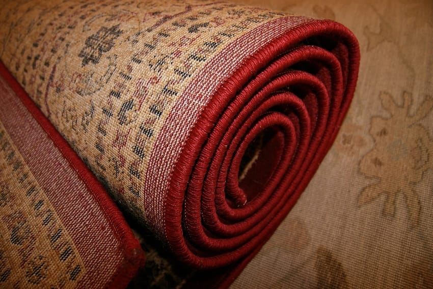 Red Persian Specialty Rug Rolled Up for Basement Storage