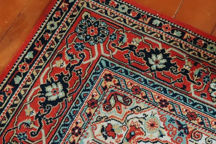 Colorful Persian rug on cherry wood floor