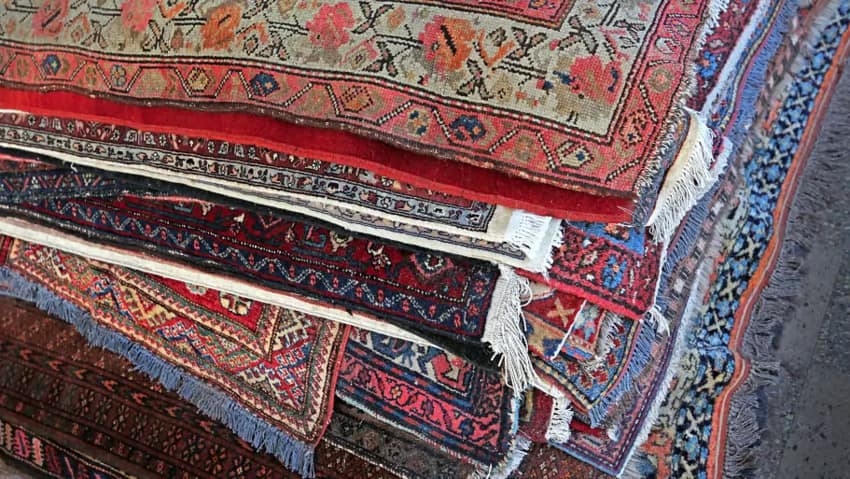 Pile of patterned Oriental rugs in assorted colors