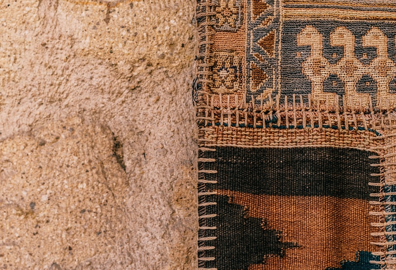 Persian rug on carpeted floor pictured close-up from above