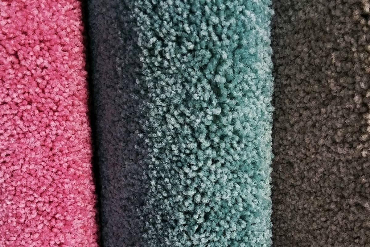 Rolls of new carpeting in pink, green and gray