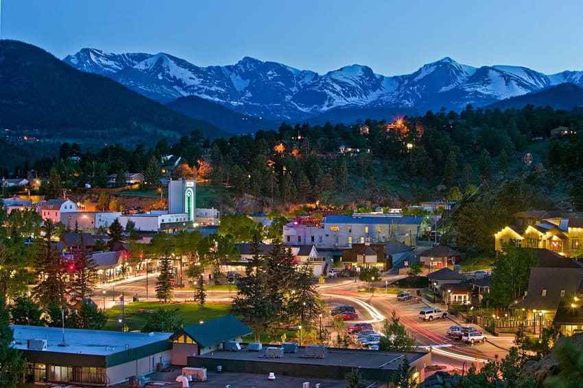 Scenic view of city landmarks and surrounding mountains in Longmont, CO at dusk